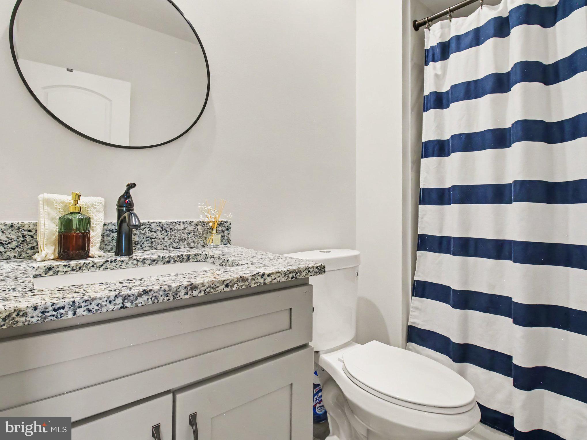 3915 Roland Avenue Baltimore, MD 21211 - Photo 11 of 26 a bathroom with a granite countertop toilet sink and mirror