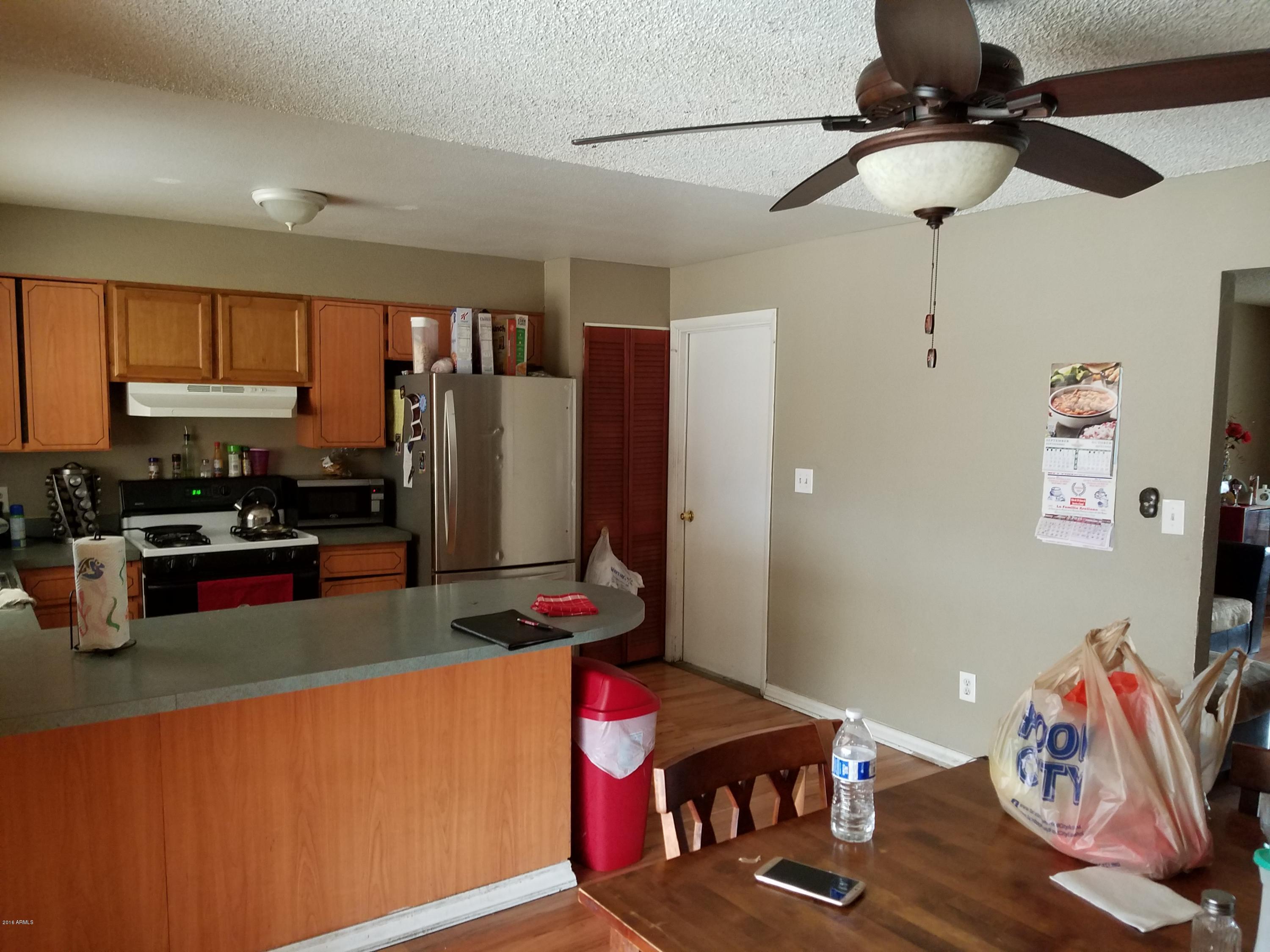 4939 West Berkeley Road Phoenix, AZ 85035 - Photo 11 of 60 a kitchen with stainless steel appliances granite countertop a refrigerator and stove