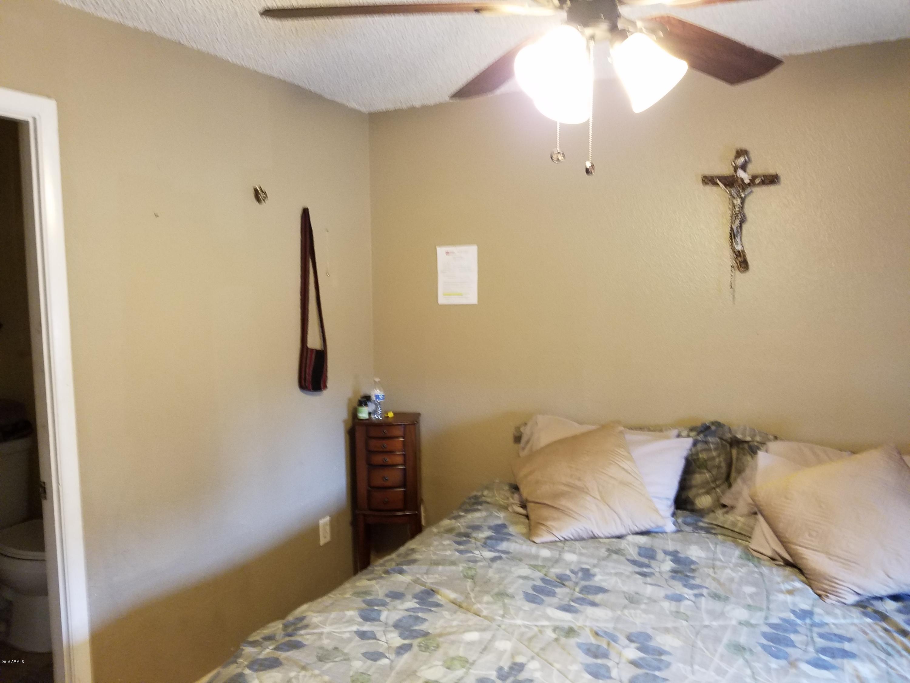 4939 West Berkeley Road Phoenix, AZ 85035 - Photo 36 of 60 a bedroom with a bed and a chandelier