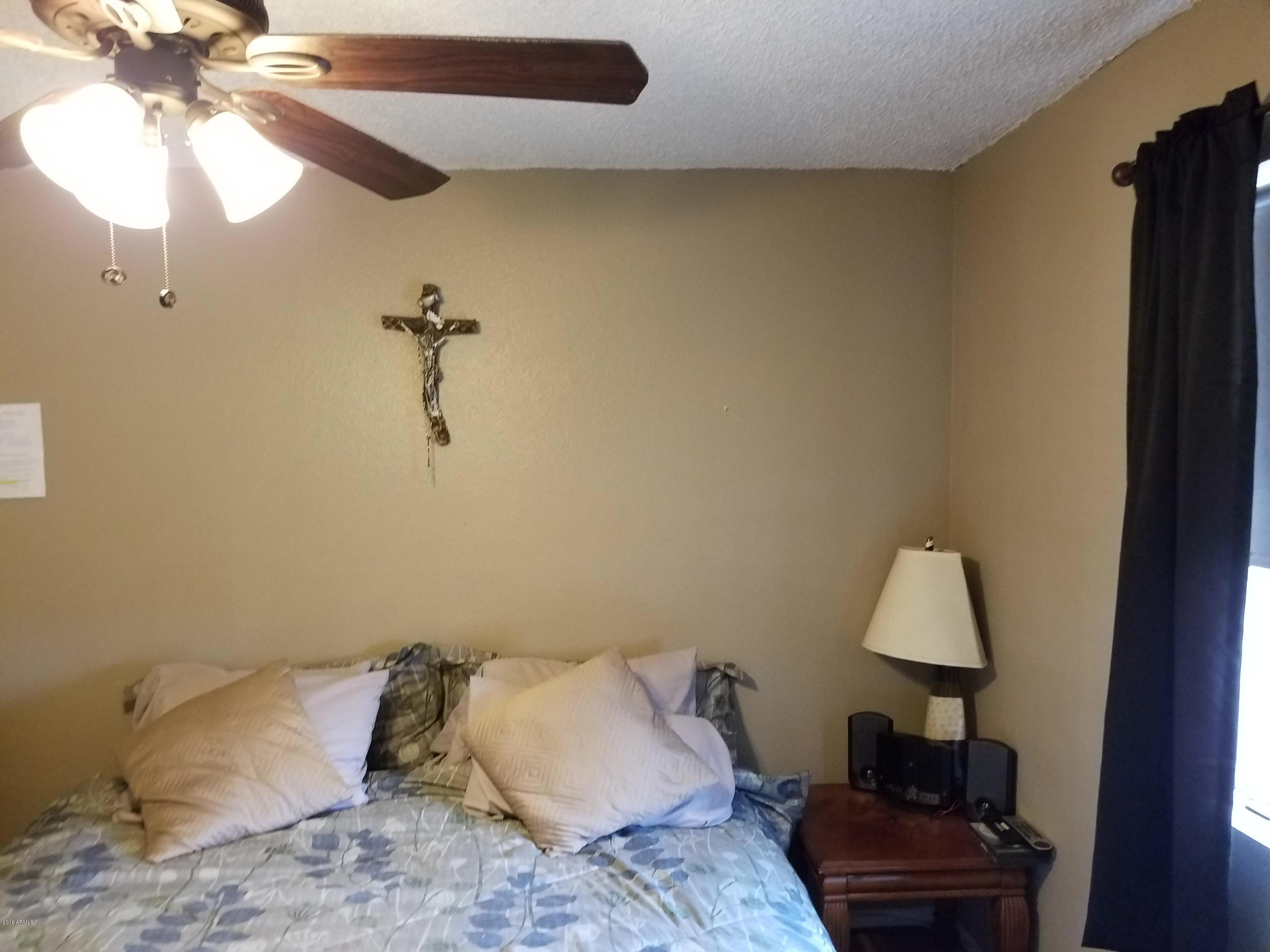 4939 West Berkeley Road Phoenix, AZ 85035 - Photo 38 of 60 a bed room with a bed and a lamp