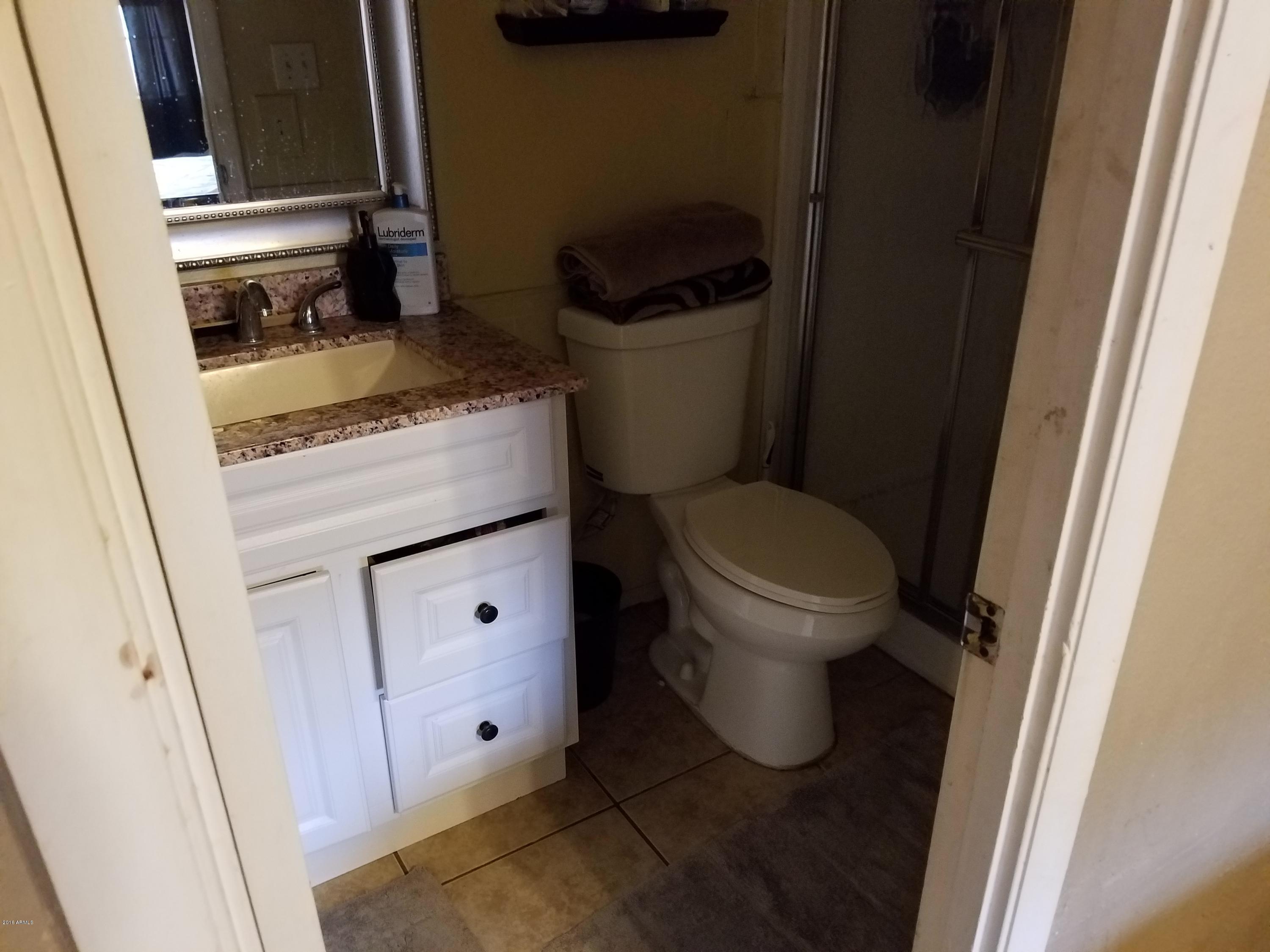 4939 West Berkeley Road Phoenix, AZ 85035 - Photo 39 of 60 a bathroom with a granite countertop toilet and a sink