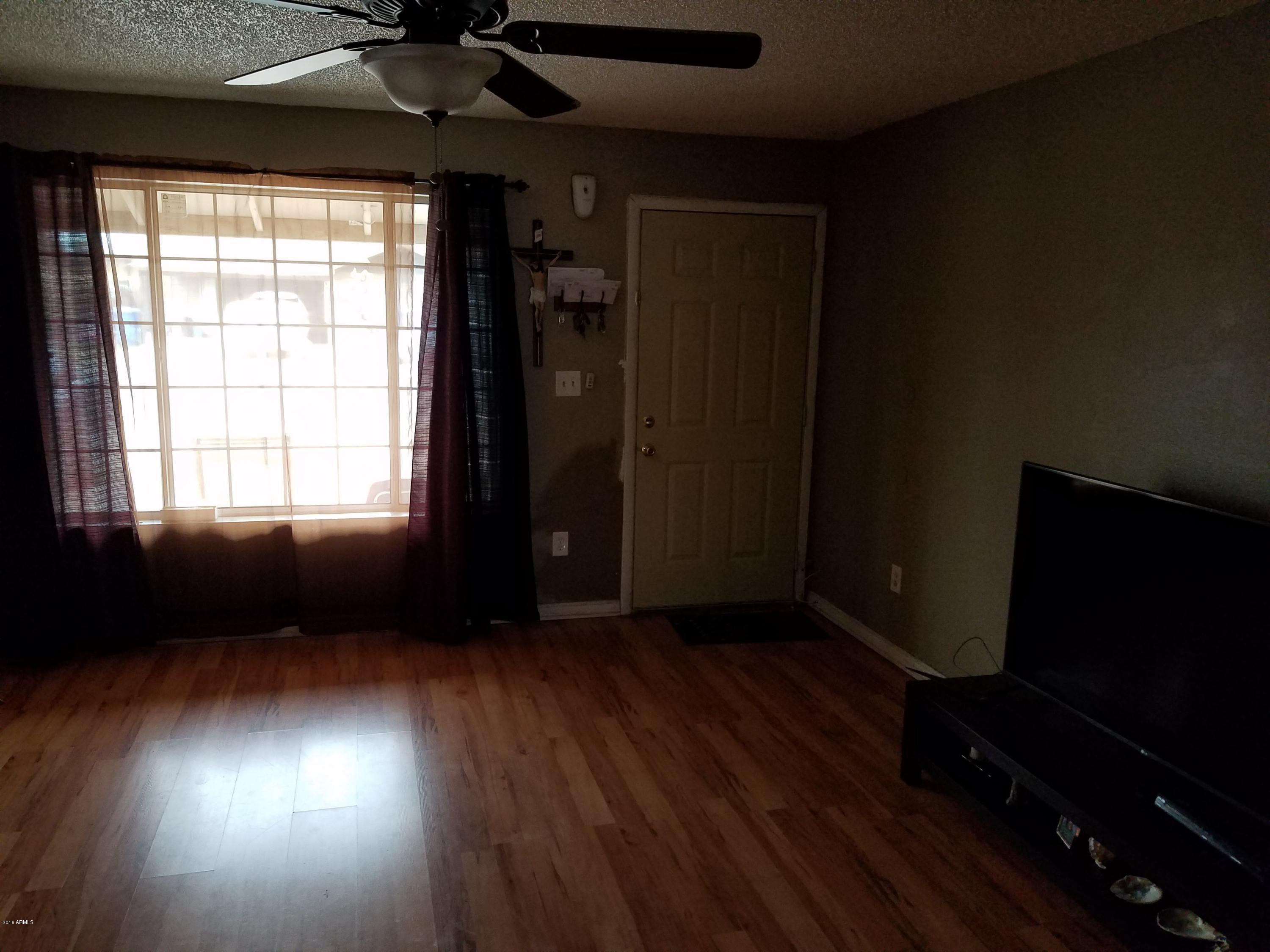 4939 West Berkeley Road Phoenix, AZ 85035 - Photo 54 of 60 an empty room with wooden floor and windows