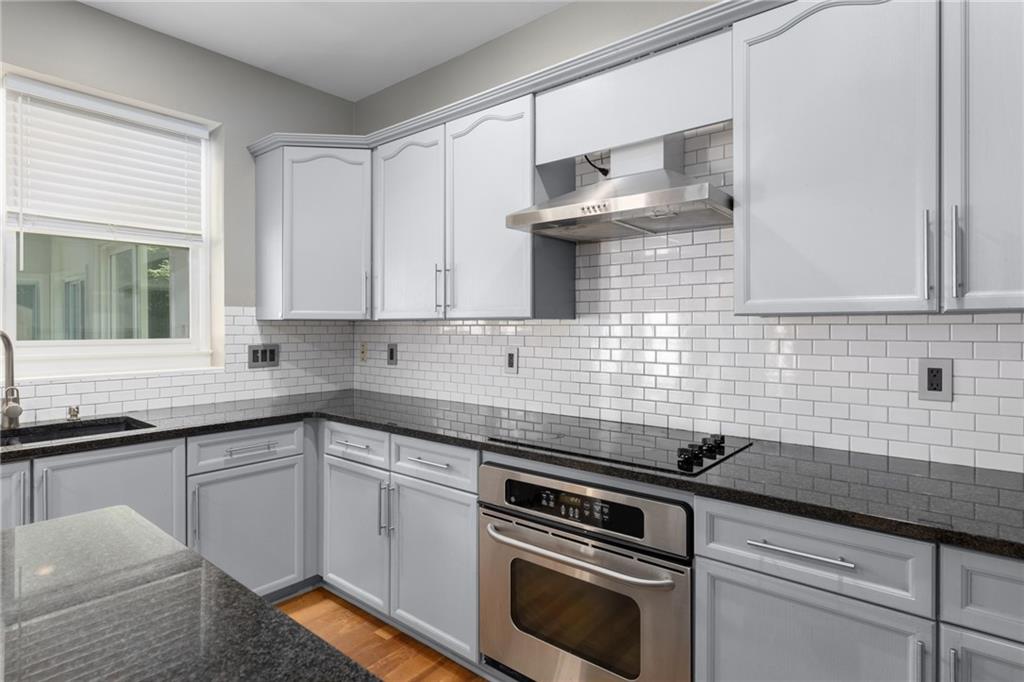 2631 East Madison Drive Atlanta, GA 30360 - Photo 25 of 66 a white kitchen with granite countertop a sink a stove and cabinets