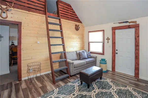 a living room with furniture a wooden floor and next to a window