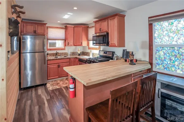 a kitchen with a stove a refrigerator and a microwave