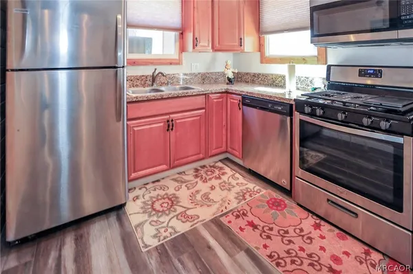 a kitchen with stainless steel appliances granite countertop a stove a sink and a refrigerator