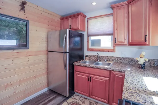 a kitchen with a refrigerator sink and cabinets