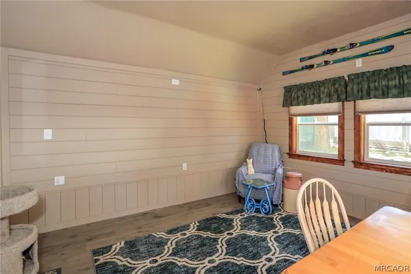 a bedroom with a chair and wooden floor