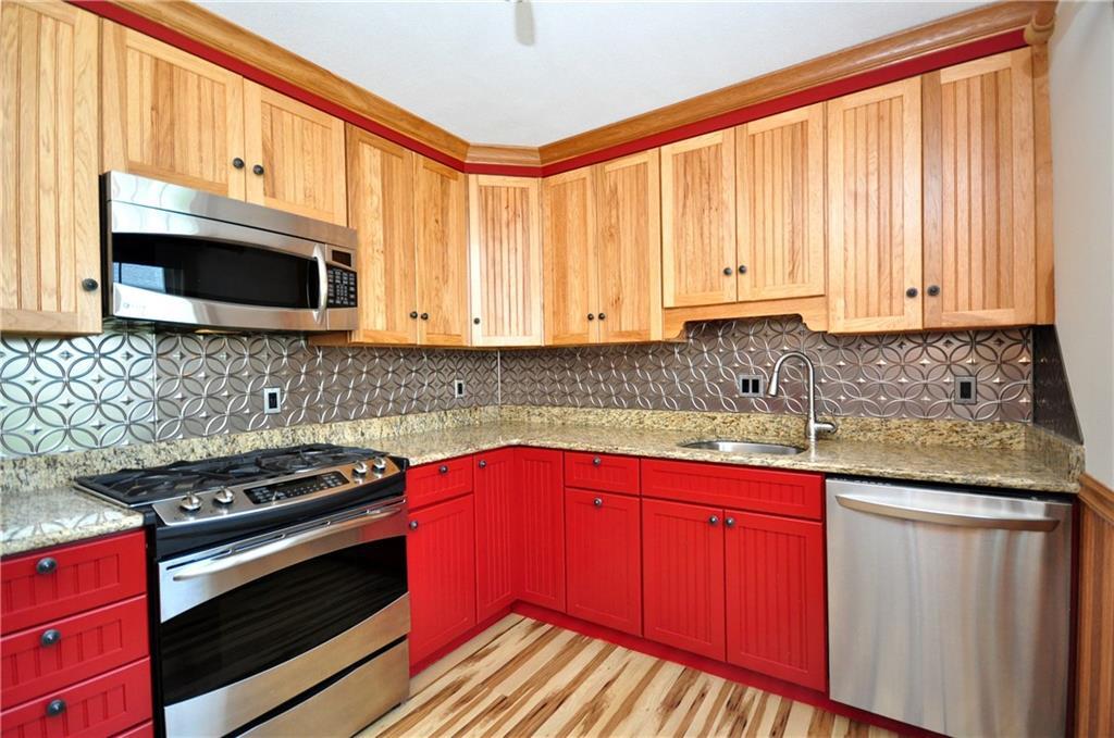 49 Tapping Reeve Village, Unit 49 Litchfield, CT 06759 - Photo 1 of 1 a kitchen with granite countertop a stove top oven microwave and cabinets