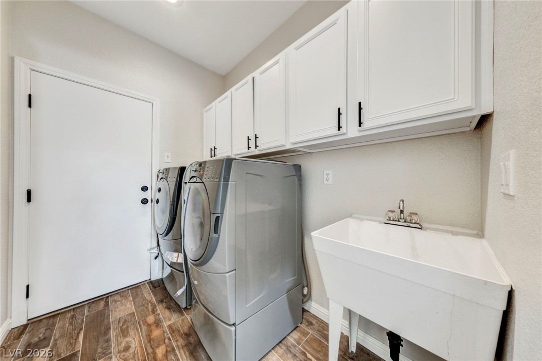 740 Aldo Rae Court, Unit NONE Henderson, NV 89052 - Photo 20 of 35 Functional laundry room equipped with a utility sink and abundant cabinet storage.