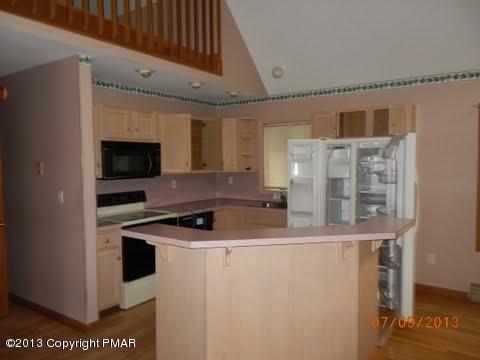2709 Radcliff Road Bushkill, PA 18324 - Photo 3 of 10 a kitchen with stainless steel appliances granite countertop a sink a stove and a microwave