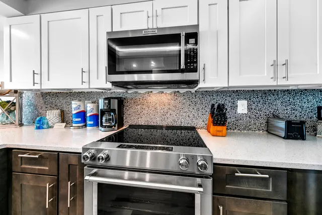 a kitchen with granite countertop a stove and a microwave