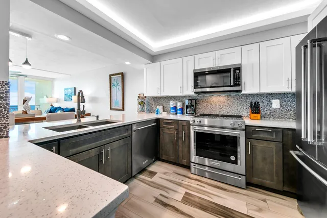 a kitchen with stainless steel appliances granite countertop a stove top oven a sink dishwasher and a microwave oven with cabinets