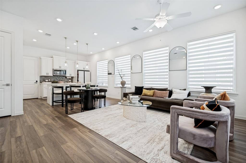 Open-concept living space with wood-finish flooring, recessed lighting, and a ceiling fan