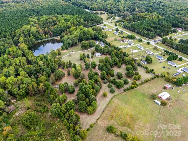 an aerial view of residential houses with outdoor space and trees all around