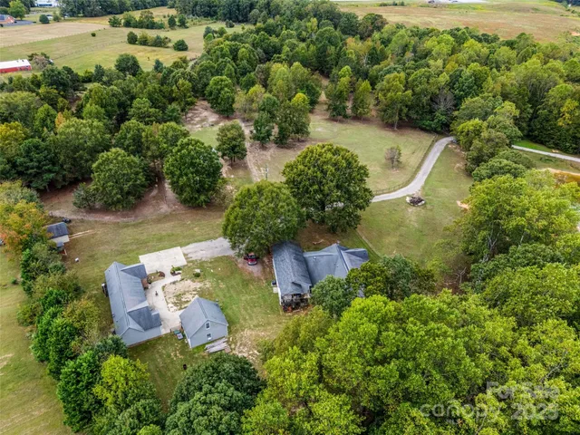 an aerial view of a house with a yard and lake view