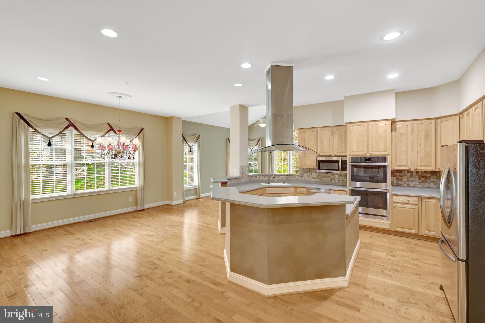 20443 Cliftons Point Street Sterling, VA 20165 - Photo 16 of 37 a large kitchen with kitchen island a large counter top space a sink stainless steel appliances and cabinets