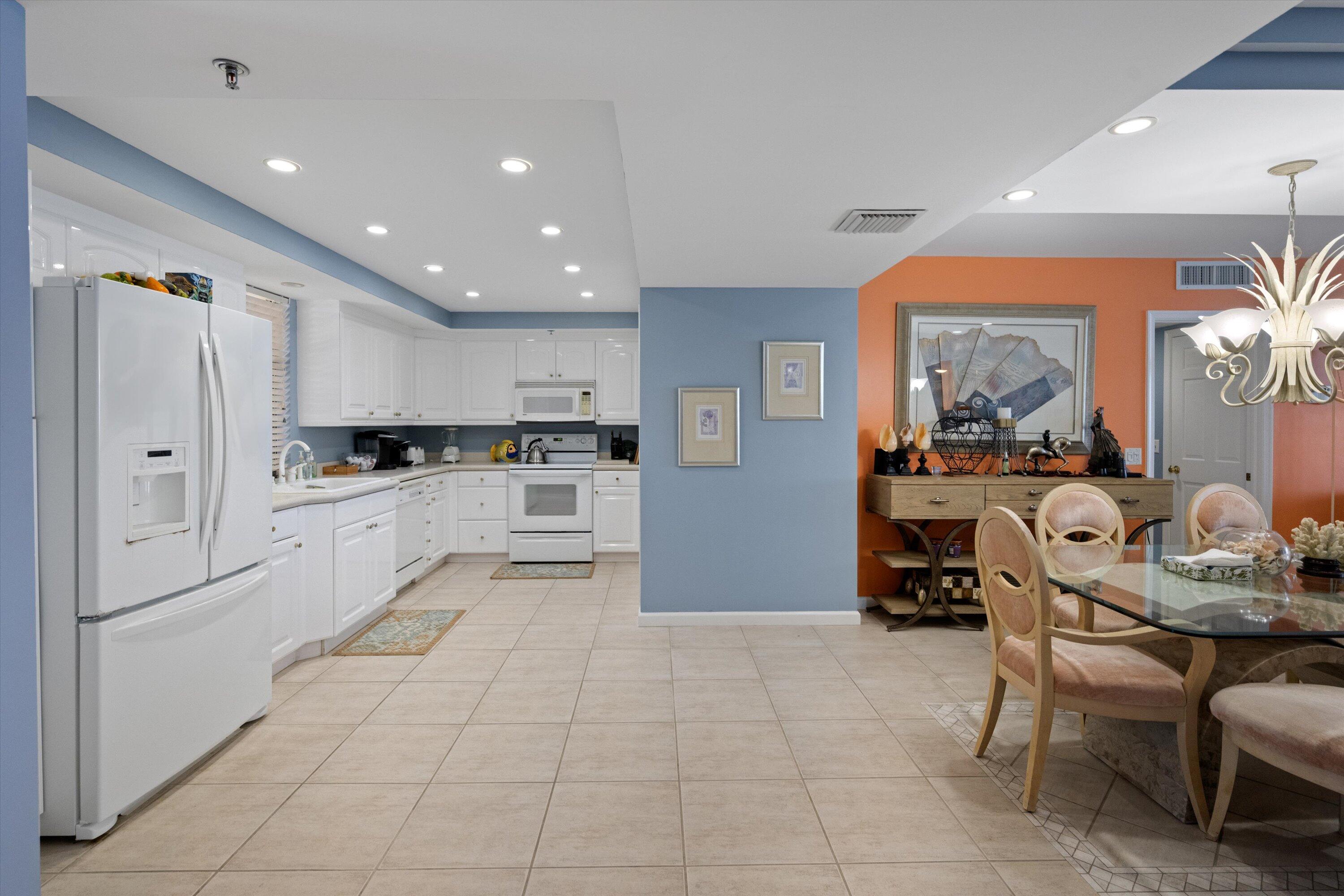 100 South Beach Road, Unit 702 Jupiter, FL 33469 - Photo 12 of 36 a kitchen with stainless steel appliances kitchen island granite countertop a refrigerator and cabinets