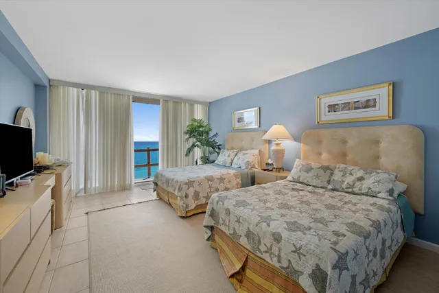 a bedroom with two beds and a flat screen tv