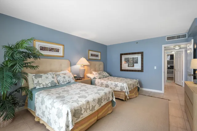 a bedroom with two beds and a potted plant