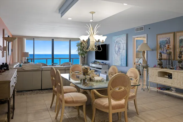 a dining room with furniture a chandelier and window