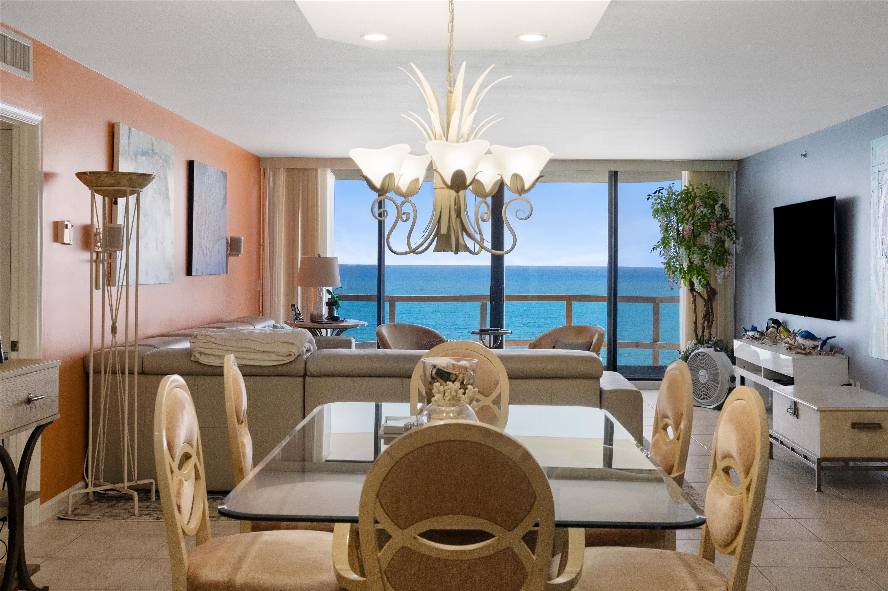 100 South Beach Road, Unit 702 Jupiter, FL 33469 - Photo 4 of 36 a living room with furniture a chandelier and a flat screen tv