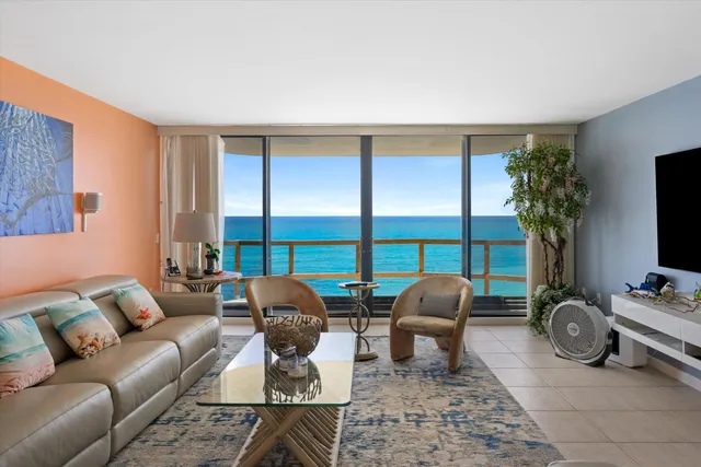 a living room with furniture a flat screen tv and a large window