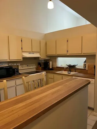 a kitchen with stainless steel appliances granite countertop a sink a stove top oven a counter space and cabinets