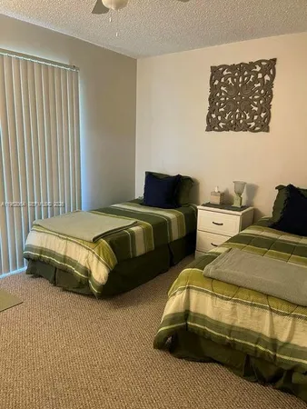 a bedroom with two beds and a painting on the wall