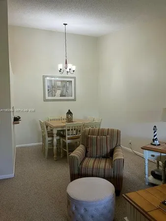 a living room with furniture a rug and a chandelier