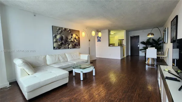 a living room with furniture and a wooden floor