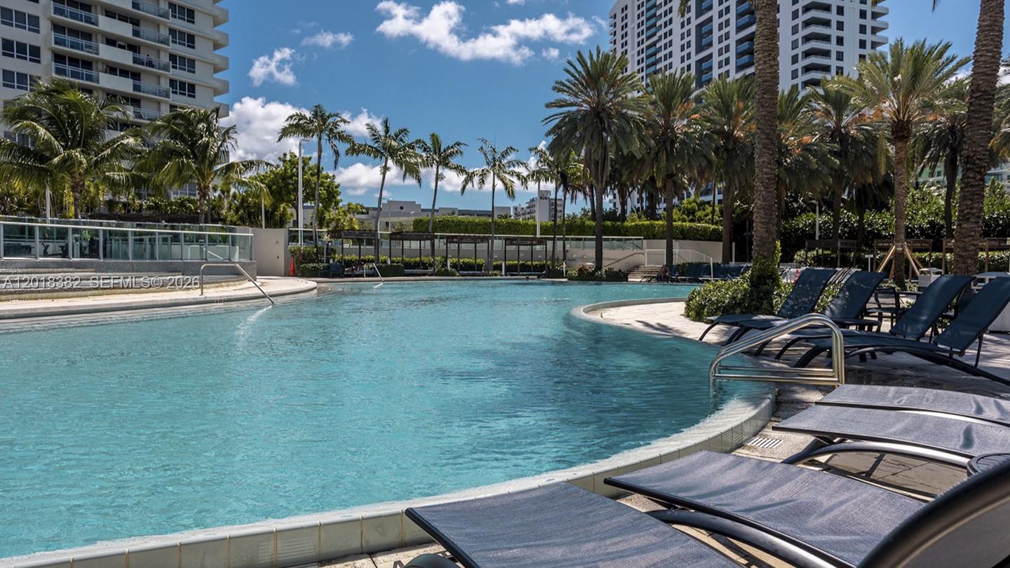 1500 Bay Road, Unit 1550S Miami Beach, FL 33139 - Photo 12 of 16 a view of a swimming pool with a table and chairs