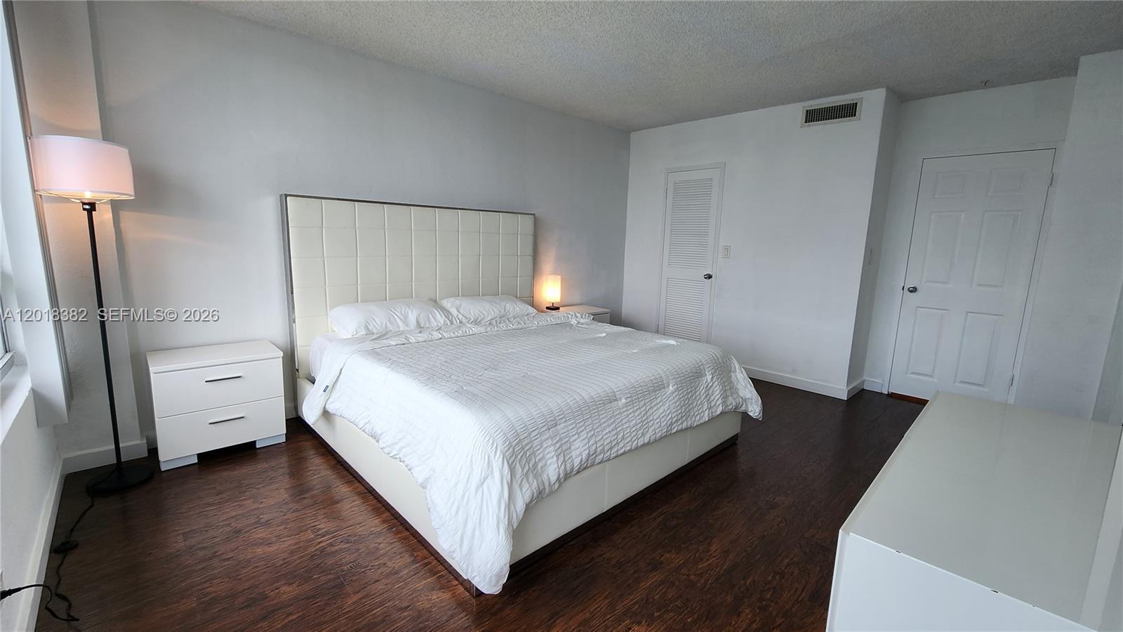 1500 Bay Road, Unit 1550S Miami Beach, FL 33139 - Photo 6 of 16 a bedroom with a bed and a lamp