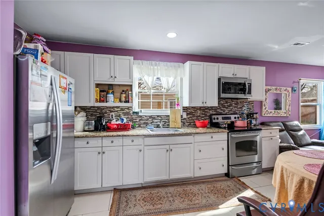 a kitchen with granite countertop a refrigerator stove top oven a sink and dishwasher