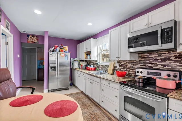 a kitchen with stainless steel appliances kitchen island granite countertop a sink stove and cabinets