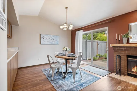 a dining room with wooden floor a chandelier a wooden table and chairs