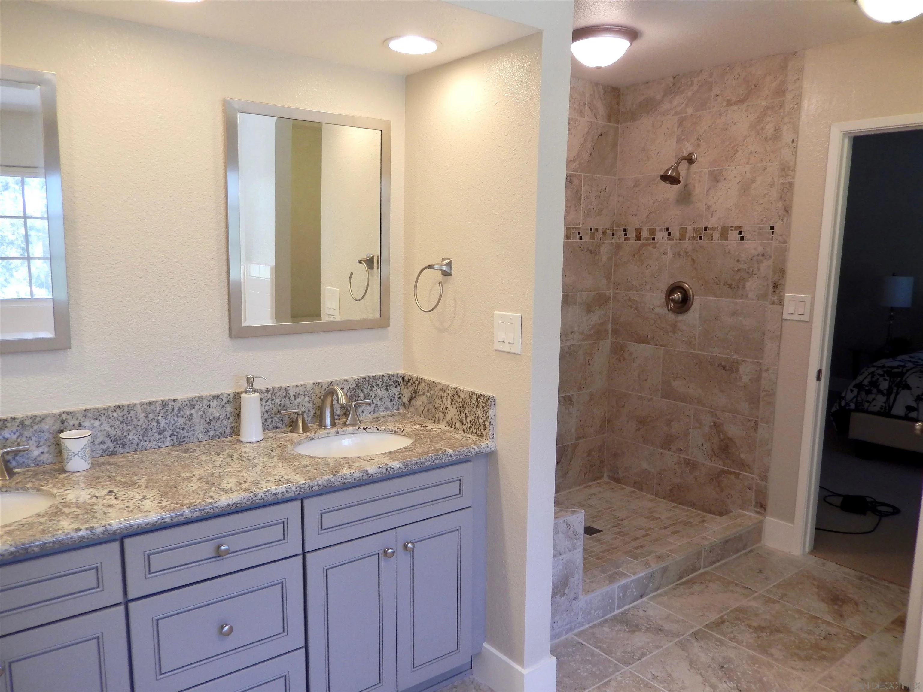 4959 Sleeping Indian Road Fallbrook, CA 92028 - Photo 12 of 22 a bathroom with a granite countertop sink a mirror a shower and a mirror