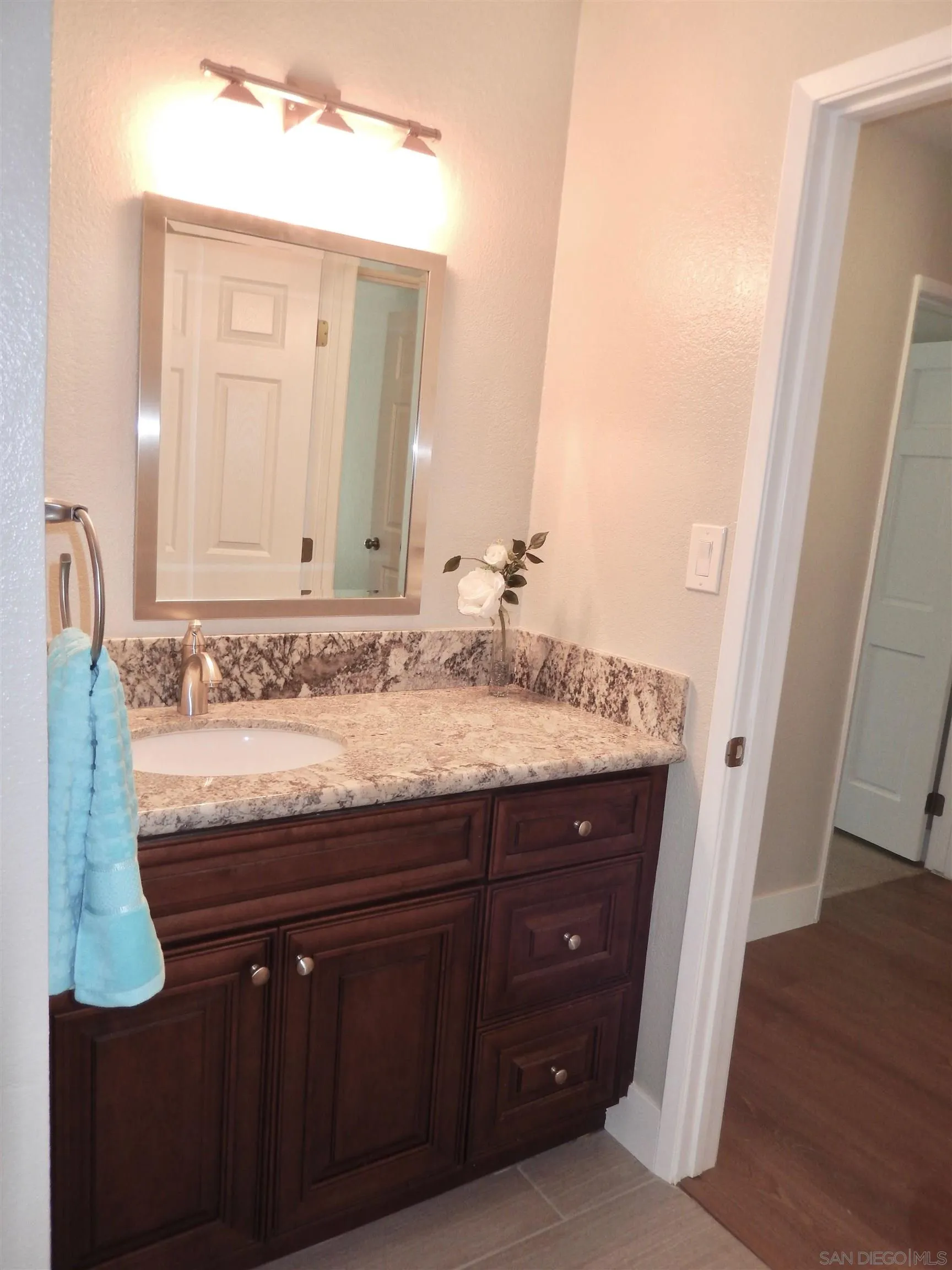 4959 Sleeping Indian Road Fallbrook, CA 92028 - Photo 19 of 22 a bathroom with a granite countertop sink a mirror and a