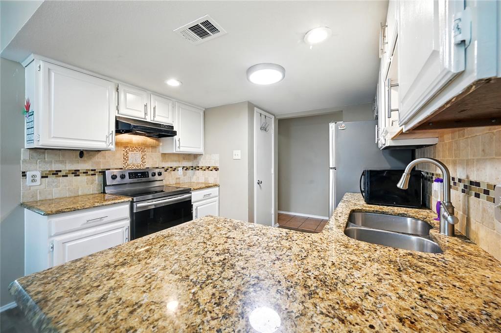 7741 Misty Ridge Drive North Fort Worth, TX 76137 - Photo 11 of 29 a kitchen with granite countertop a stove a sink and a refrigerator