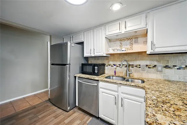 a kitchen with stainless steel appliances granite countertop a refrigerator sink and cabinets