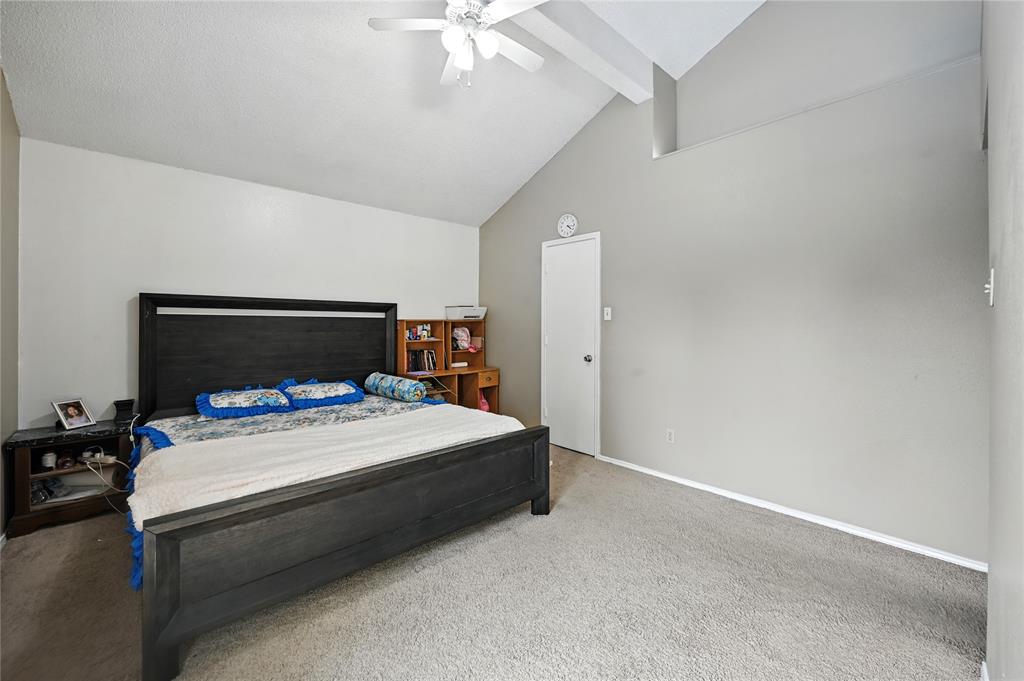 7741 Misty Ridge Drive North Fort Worth, TX 76137 - Photo 15 of 29 a bedroom with a bed and a chandelier