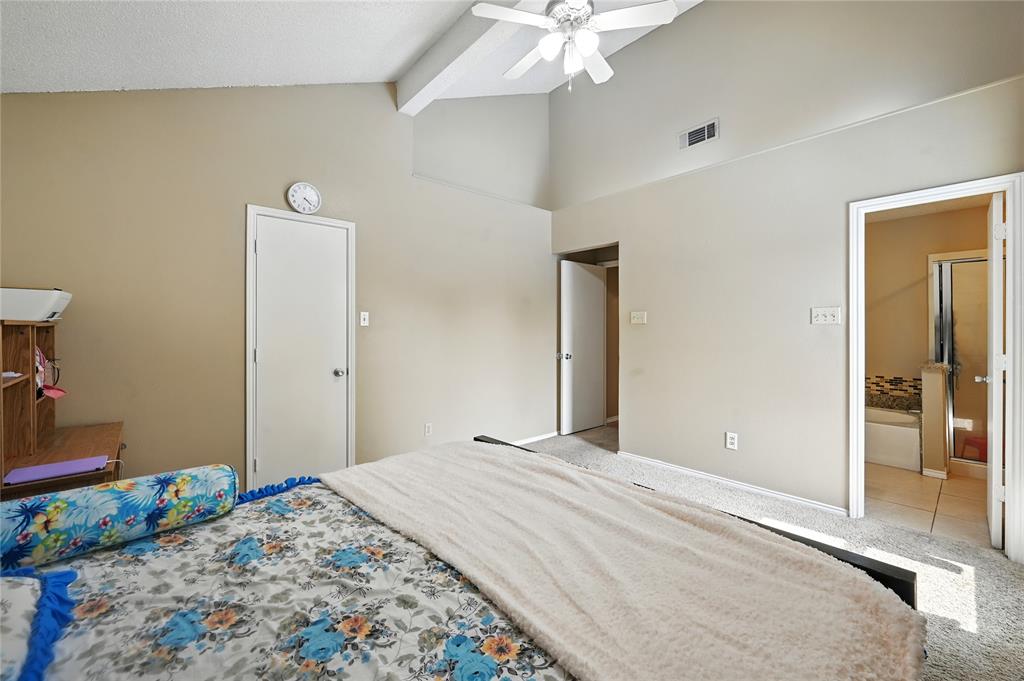 7741 Misty Ridge Drive North Fort Worth, TX 76137 - Photo 16 of 29 a bedroom with a bed and a chandelier