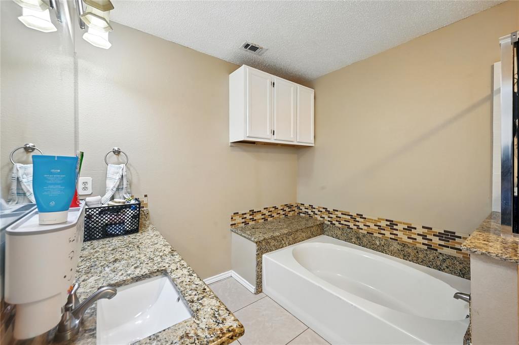 7741 Misty Ridge Drive North Fort Worth, TX 76137 - Photo 17 of 29 a bathroom with a bathtub and a sink