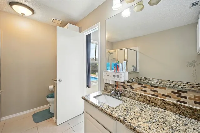 a bathroom with a granite countertop sink and a mirror