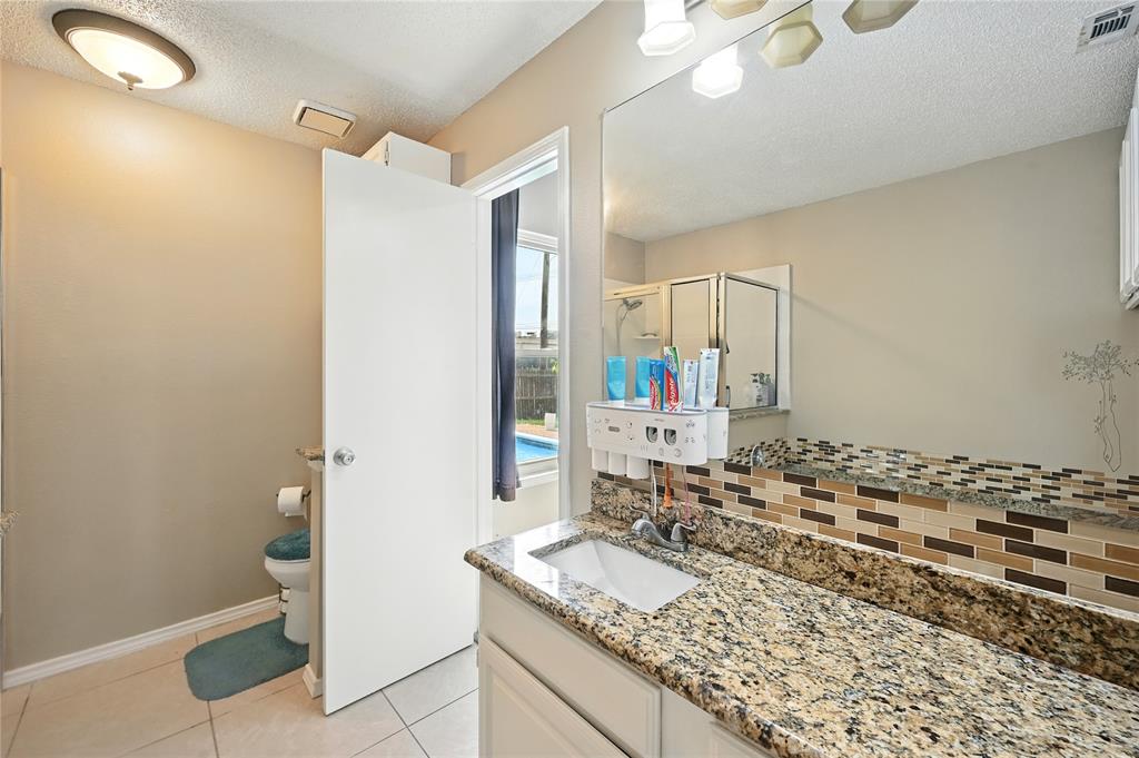7741 Misty Ridge Drive North Fort Worth, TX 76137 - Photo 19 of 29 a bathroom with a granite countertop sink and a mirror