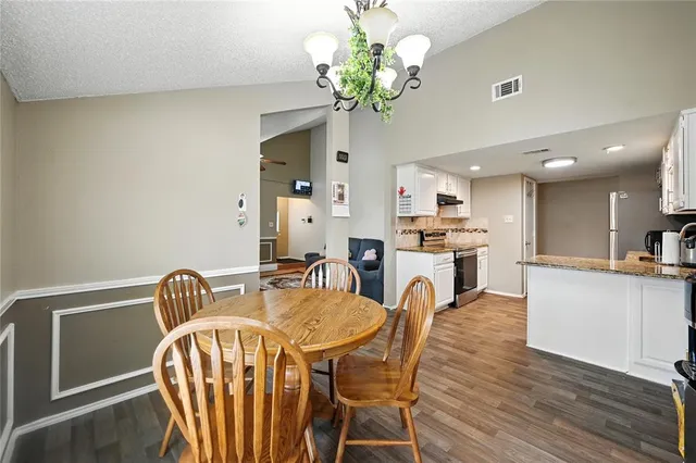 a view of a dining room with furniture and a chandelier