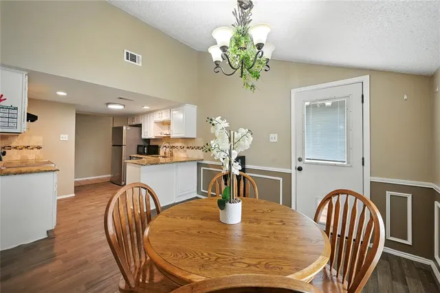 a dining room with furniture potted plants and wooden floor