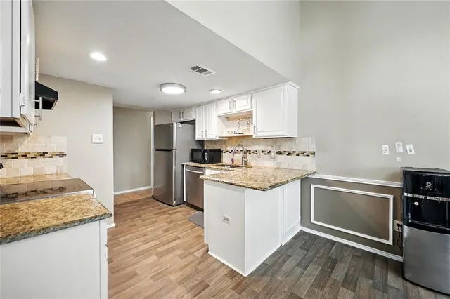 a kitchen with granite countertop a sink stove and refrigerator