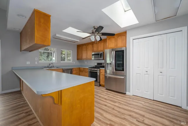 a kitchen with stainless steel appliances granite countertop a sink a stove and a refrigerator