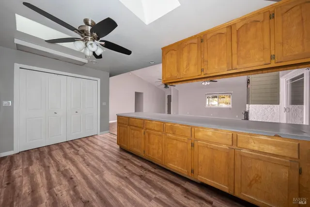 a view of a kitchen with wooden floor and a ceiling fan
